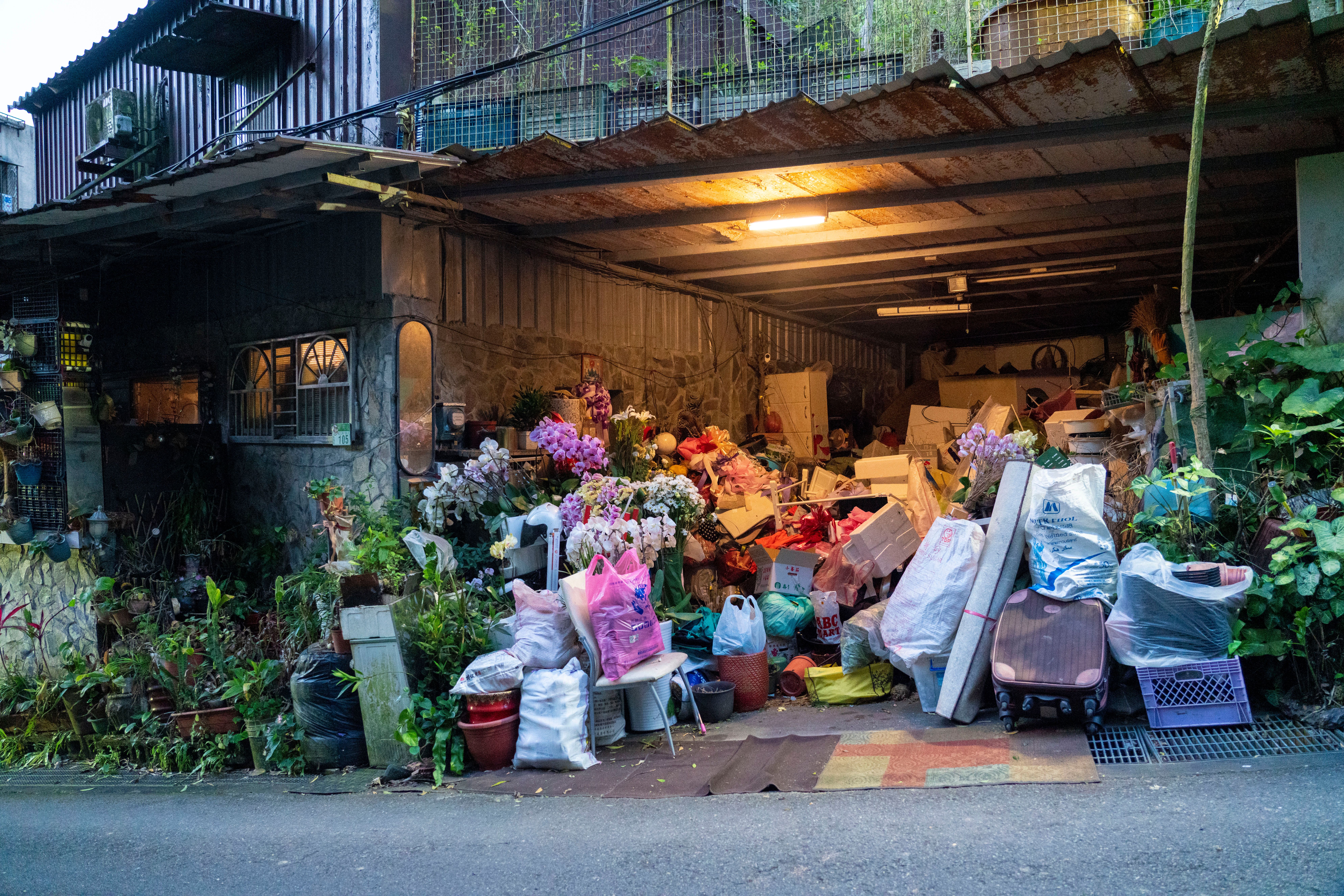 A cluttered garage overflowing with household items spilling onto the street before a cleanout
