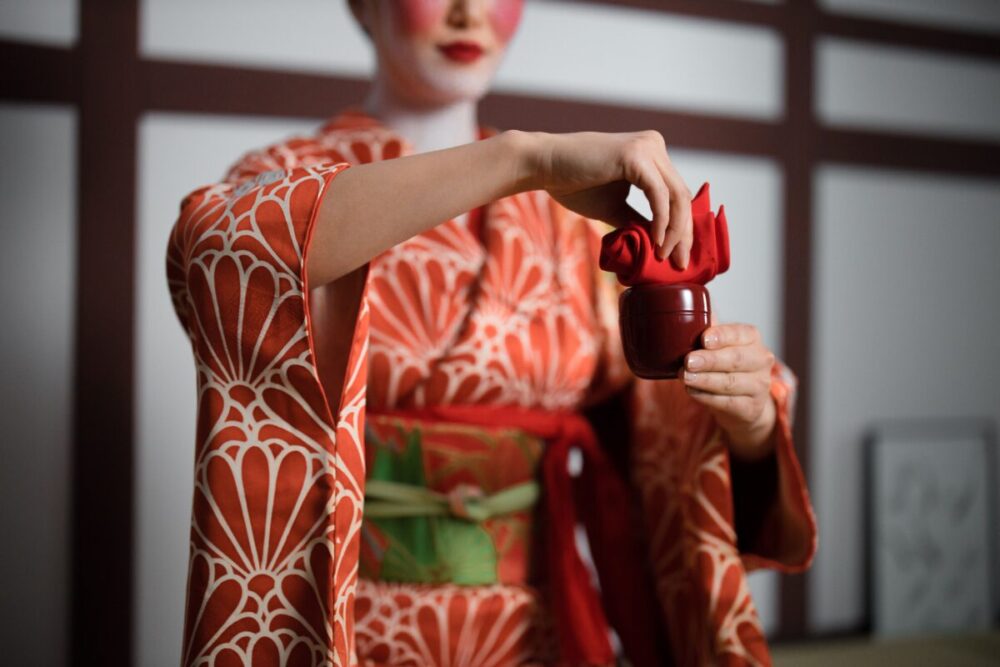 Woman in kimono performing a Japanese tea ceremony showcasing cultural elegance
