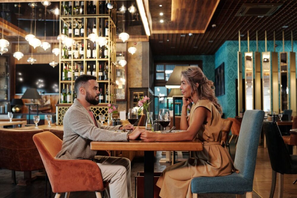 Couple enjoying a romantic dinner with wine in an elegant modern restaurant