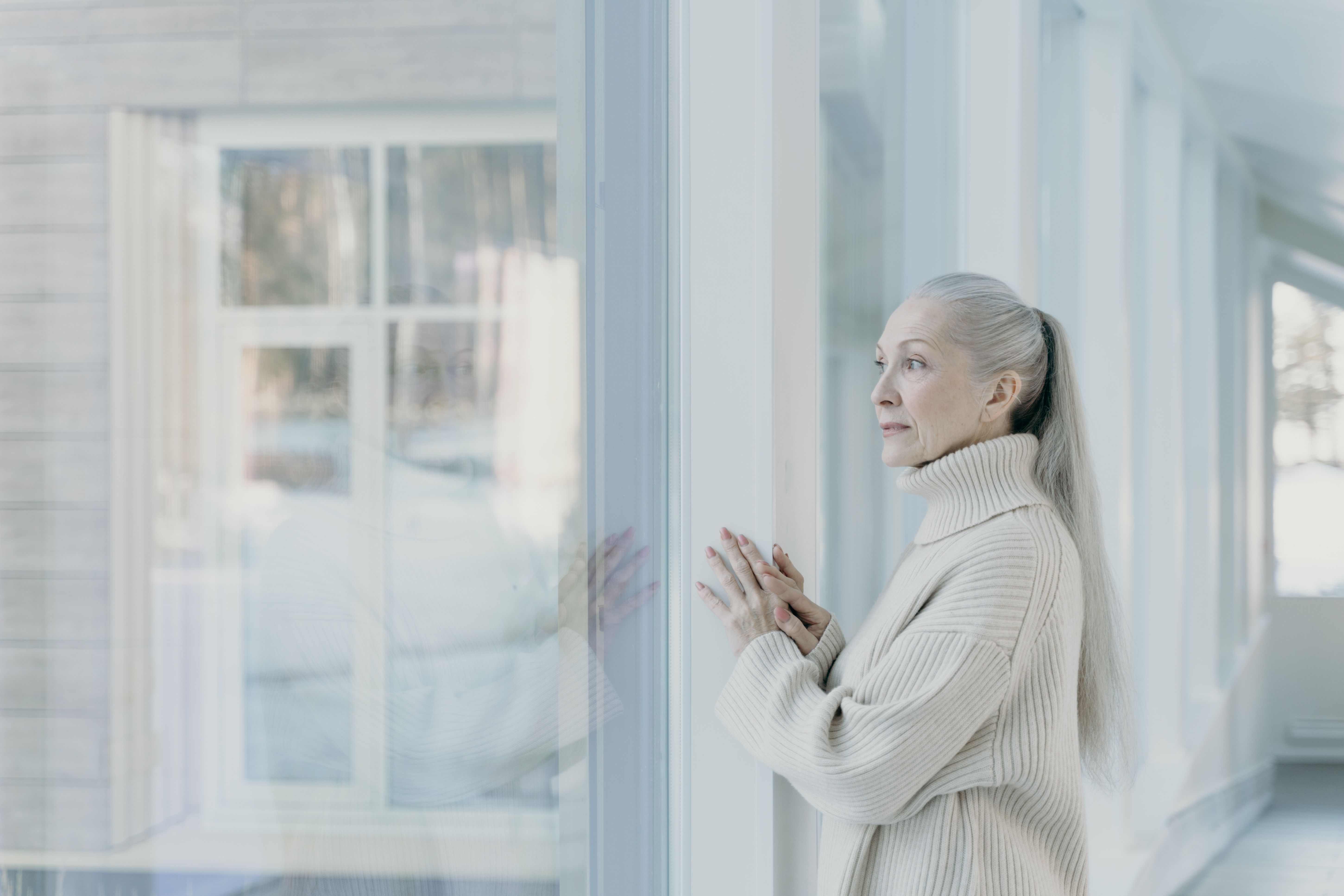 Serene person looking out a bright window, reflecting on a peaceful path forward