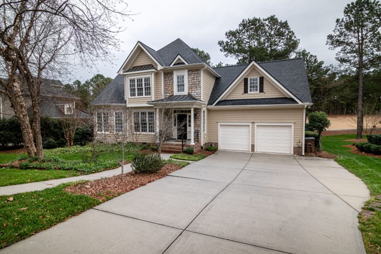 Charming suburban home with a two-car garage, manicured lawn, and clean exterior representing residential power washing in Missouri